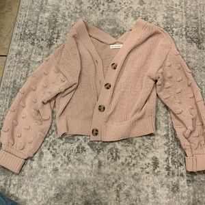 Light pink cardigan with textured sleeves.
